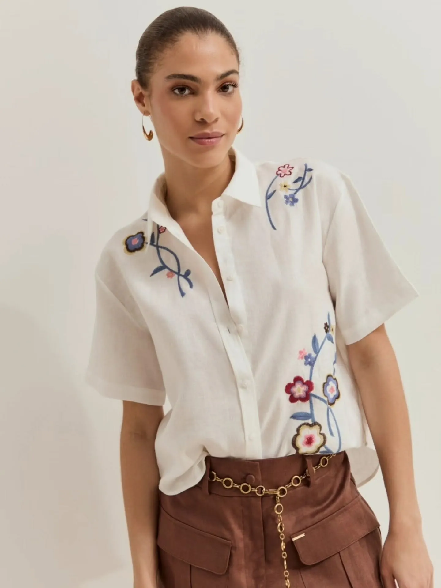 Camisa blanca bordada con flores y pantalón marrón con cinturón de cadena — Flaviano Moda
