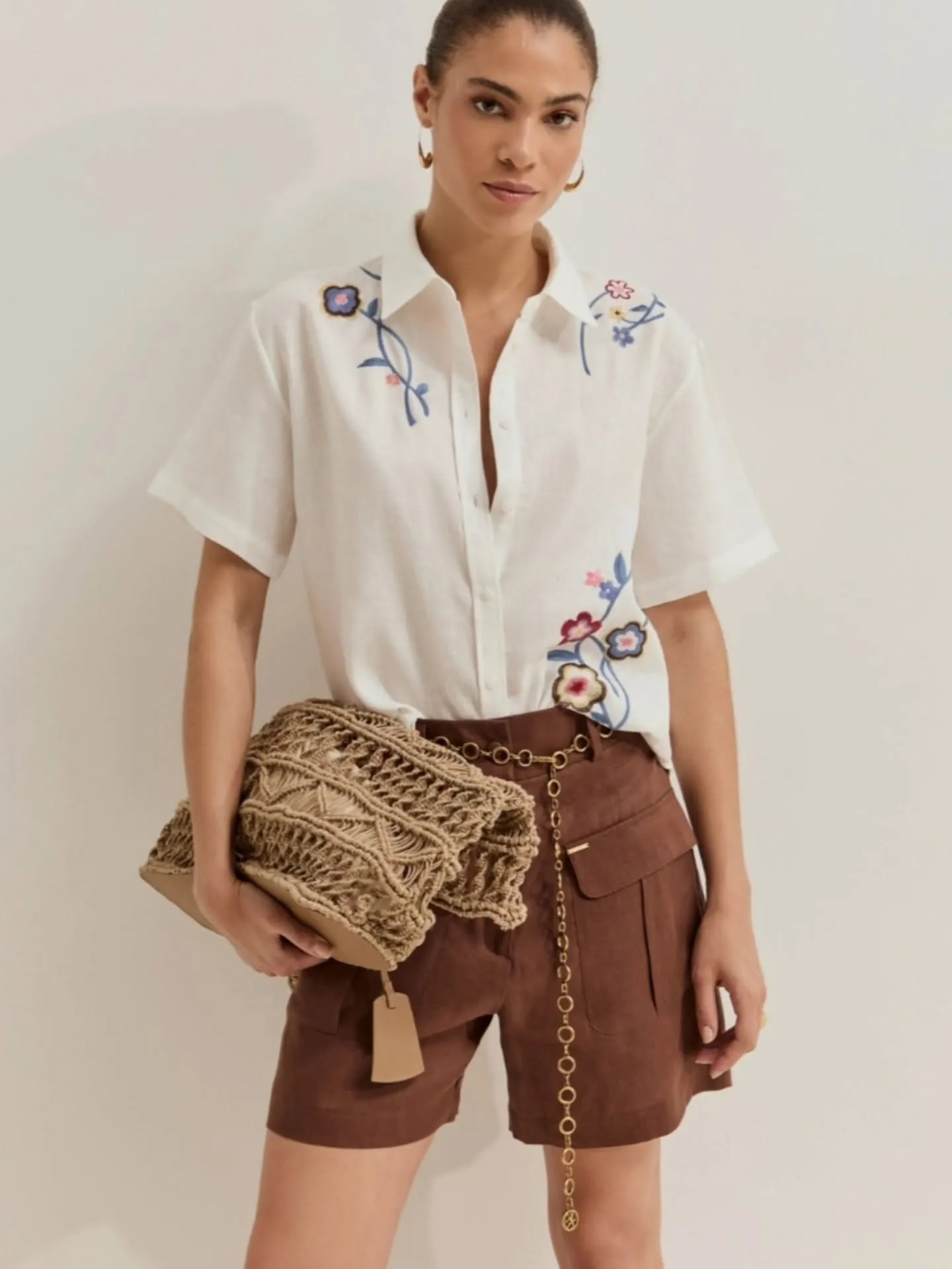 Camisa blanca bordada con flores, pantalón corto marrón y bolso de rafia — Flaviano Moda